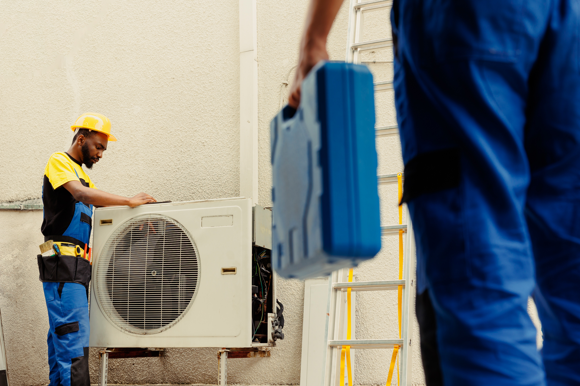 Engineer helps apprentice mend condenser